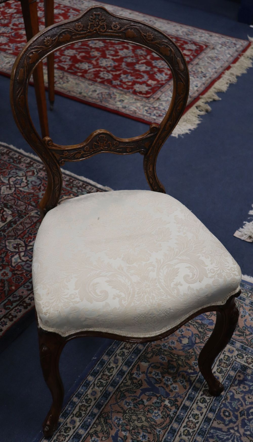 A set of six Victorian carved walnut balloon back dining chairs